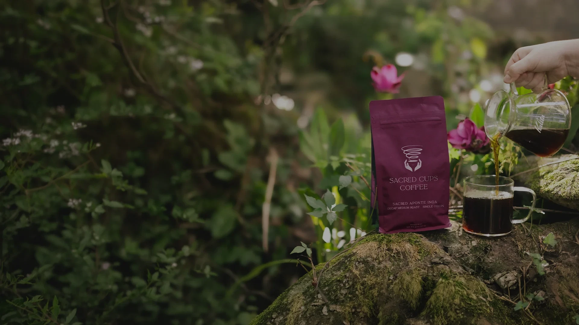 Decaf bag on a mossy stone beside a poured cup